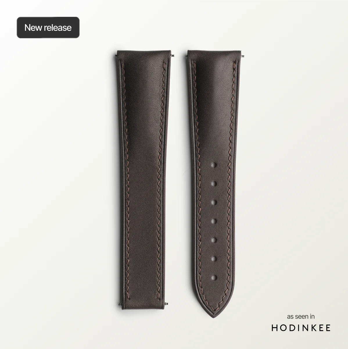 Brown leather watch strap on a light gray background with 'HODINKEE' branding.
