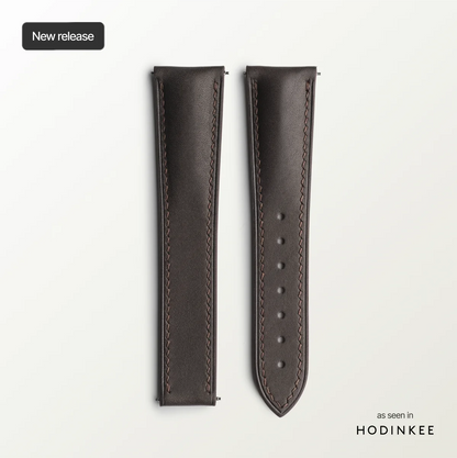 Brown leather watch strap on a light gray background with 'HODINKEE' branding.